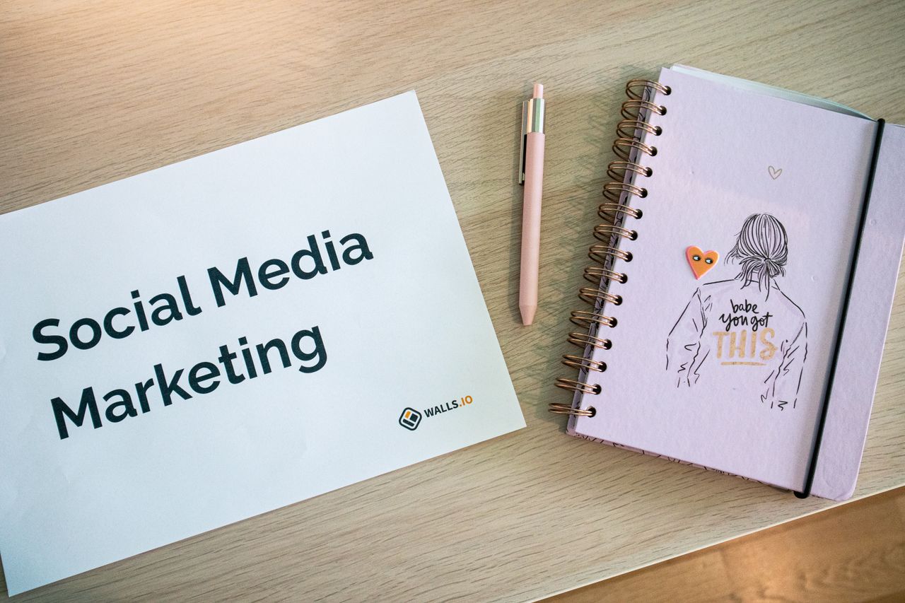 services-03 Flat lay of social media marketing paper and motivational notebook on wooden desk.